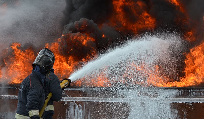 Bombero usando supresor de espuma en un incendio